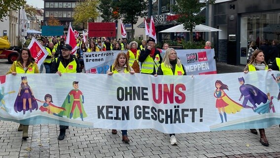 Mitglieder der Gewerkschaft ver.di halten bei einer Kundgebung ein Banner mit den Worten "Ohne uns kein geschäft!" in den Händen. © NDR Foto: Andreas Gervelmeyer