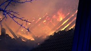 Flammen schlagen aus dem Dachstuhl eines Hauses in Hilter am Teutoburger Wald. © Nord-West-Media TV Foto: Nord-West-Media TV