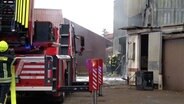 Einsatzkräfte der Feuerwehr löschen eine Lagerhalle. © Nord-West-Media-TV 