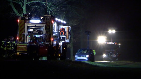 Ein Pkw steht nach einem Unfall zwischen zwei Einsatzfahrzeugen der Feuerwehr auf einer Landstraße. © Nord-West-Media TV 