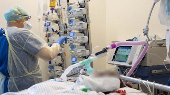Ein Krankenpfleger steht am Bett eines Intensivpatienten hinter einem Dialysegerät. © dpa-Bildfunk Foto: Friso Gentsch