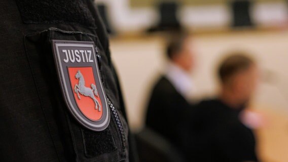 "Justiz" und das niedersächsische Wappen, aufgenommen am Ärmel eines Justizbeamten in einem Saal vom Landgericht. © picture alliance/dpa Foto: Friso Gentsch