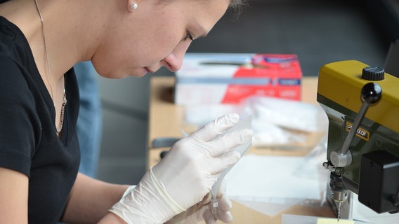 Eine Forscherin untersucht einen Gegenstand aus einer Ausgrabung zur Varusschlacht. © VARUSSCHLACHT im Osnabrücker Land GmbH 