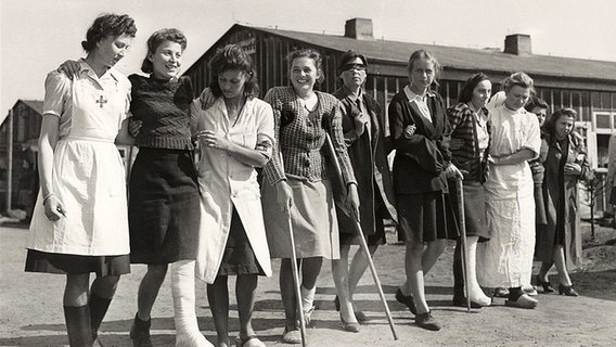 Eine Schwarz-Weiß-Aufnahme von Frauen, die Arm in Arm in einer Reihe stehen. © Library and Archives Canada / Alexander M. 