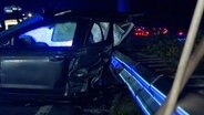 Rettungskräfte stehen nach einem schweren Unfall auf der A31 bei Lingen hinter einem stark beschädigten Pkw. © Nordwestmedia TV 