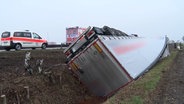 Ein Lastwagen liegt nachdem err von der A1 bei Neuenkirchen abgekommen ist, im Straßengraben auf dem Dach. © Nord-West-Media TV 