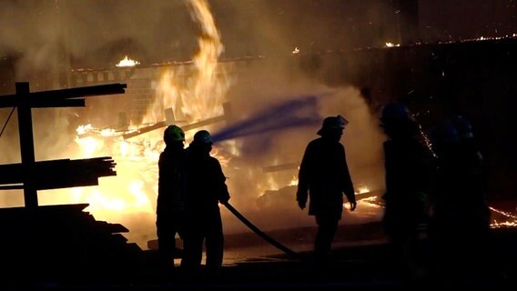 Einsatzkräfte der Feuerwehr löschen den Brand in einem Sägewerk in Melle. © Nord-West-Media TV 