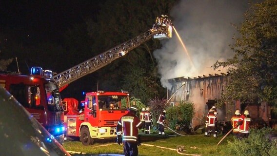 Feuerwehrleute löschen ein brennendes Gebäude  in Menslage. © Nord-West-Media TV 