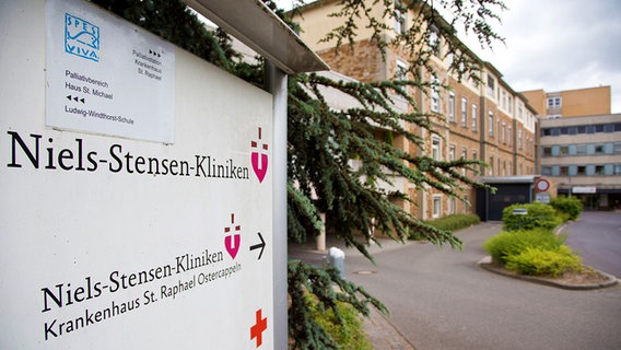 Vor einem großen Gebäude steht ein Schild mit der Aufschrift "Niels-Stensen-Kliniken". © dpa - Bildfunk Foto: Friso Gentsch