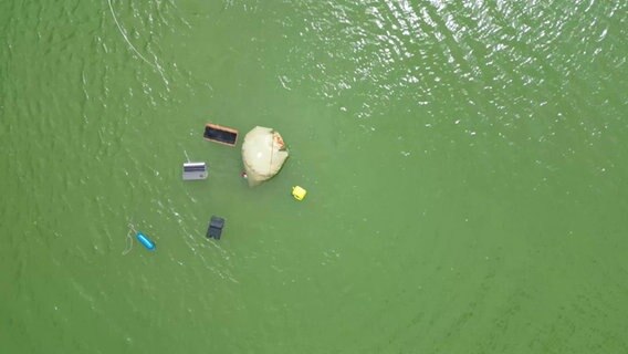 Verschiedene Geegnstände sind an der Unfallstelle in Bramsche (Mittellandkanal) aufgetaucht. Ein Sportboot war mit einem Binnenschiff kollidiert und gesunken. © TV7News 