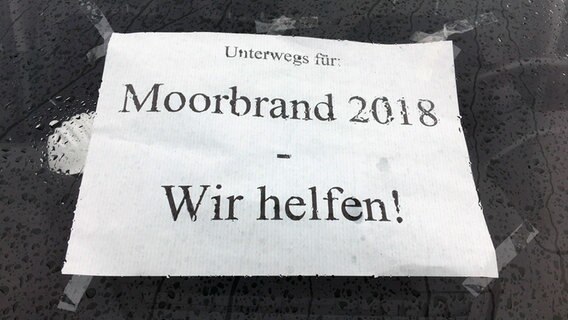 Auf einem Blatt Papier steht "Unterwegs für: Moorbrand 2018 - Wir helfen!". © NDR Foto: Hedwig Ahrens