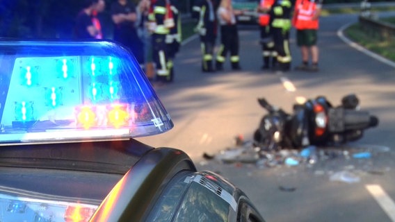 Ein Streifenwagen steht vor einem Roller nach einem Unfall in Neuenkirchen, im Hintergrund Rettungskräfte. Ein Streifenwagen steht vor einem Roller nach einem Unfall in Neuenkirchen, im Hintergrund Rettungskräfte. © Nord-West-Media-TV