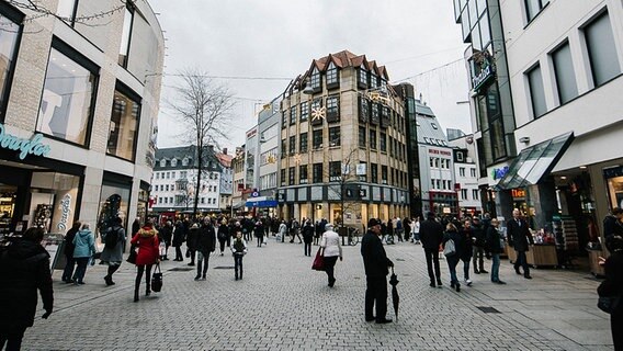 Passanten gehen in Osnabrück durch die Fußgängerzone, die weihnachtlich geschmückt ist © NDR Foto: Julius Matuschik