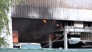 Eine Halle auf einem Recyclinghof steht in Flammen. © Nord-West-Media TV 