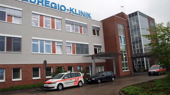 Vor dem Eingang der Euregio-Klinik in Nordhorn stehen drei Fahrzeuge. Vor dem Eingang der Euregio-Klinik in Nordhorn stehen drei Fahrzeuge. © NDR Foto: Hedwig Ahrens