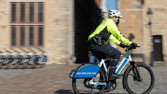 Ein Polizist fährt auf einem Pedelec mit Sondersignalanlage wie Blaulicht und Martinshorn. © dpa-Bildfunk Foto: Friso Gentsch/dpa