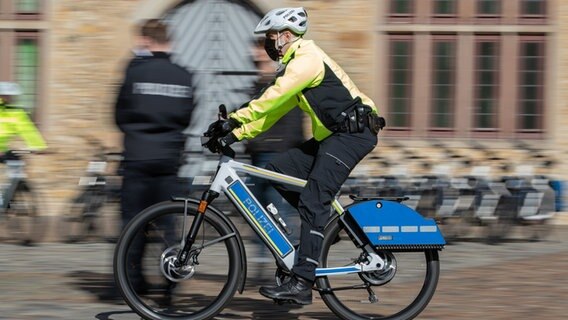 Ein Polizist fährt auf einem Pedelec mit Sondersignalanlage wie Blaulicht und Martinshorn. © dpa-Bildfunk Foto: Friso Gentsch/dpa