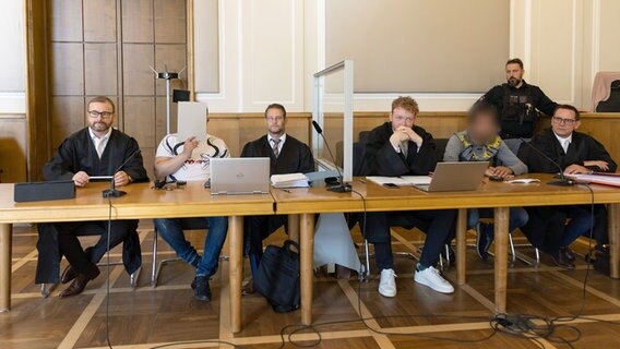Angeklagte sitzen in einem Gerichtssaal. © dpa Foto: Friso Gentsch