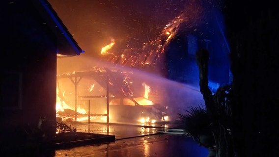 Feuerwehr löschen ein brennendes Haus und ein brennendes Auto in Quakenbrück in der Silvesternacht. © Nord-West-Media TV 