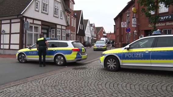 Polizisten sperren mit Polizeiautos und Flatterband eine Straße in Quakenbrück. © Nord-West-Media TV 
