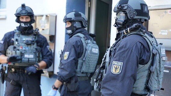 Polizeibeamte stehen vor einem Wohnhaus. © Festim Beqiri/Tv7news/dpa 
