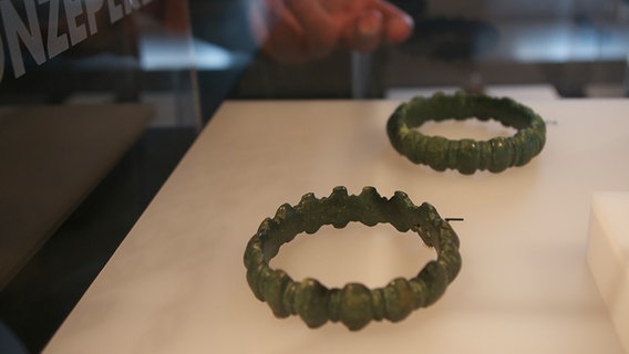 Zwei Armreife aus Bronze liegen in einem Schaukasten im Museum Schnippenburg. © NDR Foto: Kora Blanken