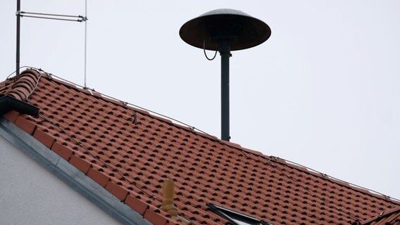 Eine Sirene auf einem Hausdach. © picture alliance Foto: Stephan Jansen