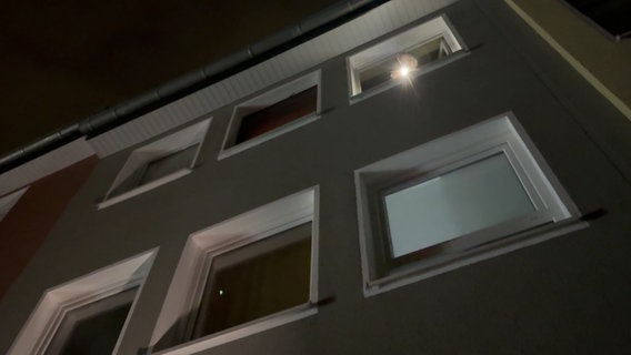 Ein Mann leuchtet mit einer Taschenlampe aus einem Wohnhaus in Osnabrück. © TV7News 