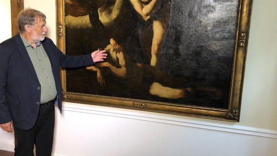 Ein Mann zeigt im Museum am Herrenberg ein Gemälde des Malers Jacopo Tintoretto. © NDR Foto: Hedwig Ahrens