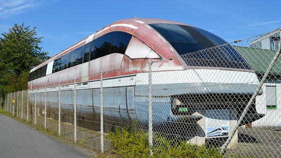 Ein alter Transrapid steht hinter einem Zaun. © NDR Foto: Hedwig Ahrens