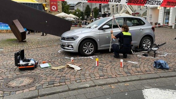 Eine Polizistin untersucht das Unfallauto in der Osnabrücker Innenstadt. © Nord-West-Media TV 