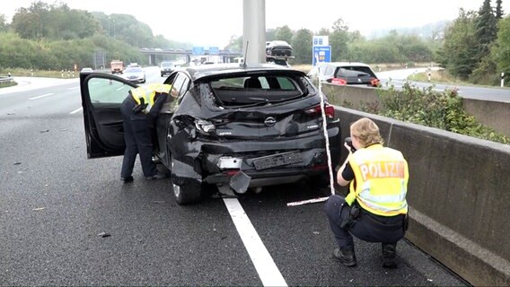 Polizistinnen untersuchen ein zerstörtes Unfallauto auf der Autobahn. © Nord-West-Media TV 
