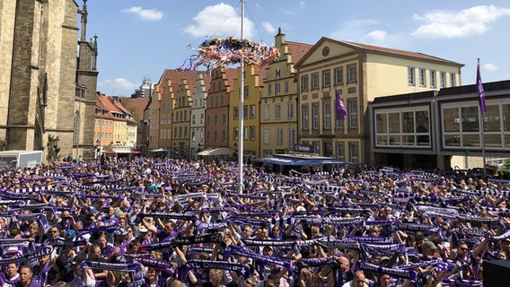 Zur Feier des Aufstiegs des VfL Osnabrück feiert den Aufstieg aus der dritten in die zweite Fußball-Bundesliga haben sich zahlreiche Fans am Rathaus versammelt und halten Fanschals hoch. © NDR Foto: Marlena Maerz