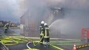 Feuerwehrleute löschen eine brennende Scheune. © Nord-West-Media TV 