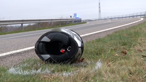 Ein Motorradhelm liegt nach einem Unfall auf einer Straße bei Wietmarschen. © Nord-West-Media TV 