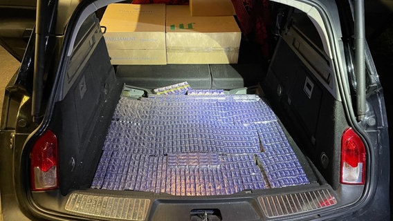 Viele Stangen Zigaretten liegen in einem Kofferraum eines Pkw. © Polizeiinspektion Diepholz 
