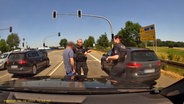 Eine Dashcam-Aufnahme zeigt Polizisten die einen Autofahrer kontrollieren. © Nord-West-Media TV 