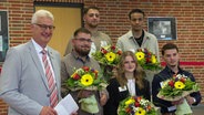 Für ihr couragiertes Eingreifen sind fünf junge Erwachsene vom Diepholzer Landrat Cord Bockhop (li.) geehrt worden. Sie hatten eine junge Frau vor einem Messerangreifer gerettet. © NDR Foto: NDR