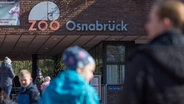 Menschen stehen vor dem Eingang des Zoos in Osnabrück. © picture alliance/dpa/Friso Gentsch Foto: Friso Gentsch