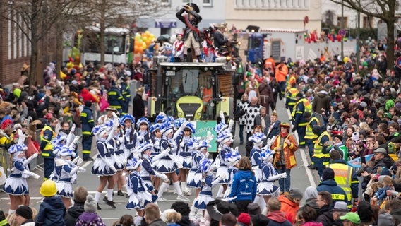 Karnevalisten feiern auf ihren Mottowagen beim traditionellen Karnevalsumzug "Ossensamstag". © picture alliance/dpa Foto: Friso Gentsch