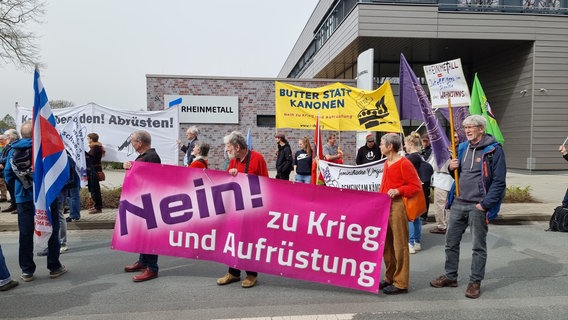 "Nein! zu Krieg und Aufrüstung" steht auf einem Banner von Teilnehmern eines Ostermarsches, die am 30. März 2024 vor dem Gelände des Rüstungskonzerns Rheinmetall in Unterlüß im Landkreis Celle demonstrieren. © dpa-Bildfunk Foto:  -/dpa