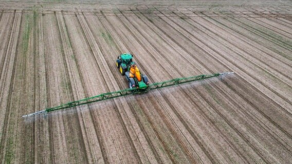 Pestizide werden mit einem Traktor auf ein Feld aufgetragen. © picture alliance / Jochen Tack Foto: Jochen Tack