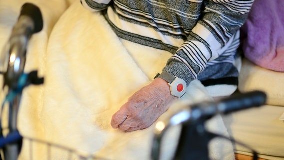Eine alte Frau sitzt auf einem Bett, vor ihr ein Rollator. © dpa/picture alliance Foto: Britta Pedersen