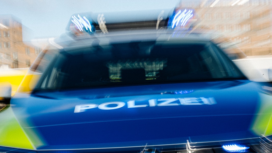 Ein mit Bewegungsunschärfe fotografierter Streifenwagen der Polizei in der Frontansicht.