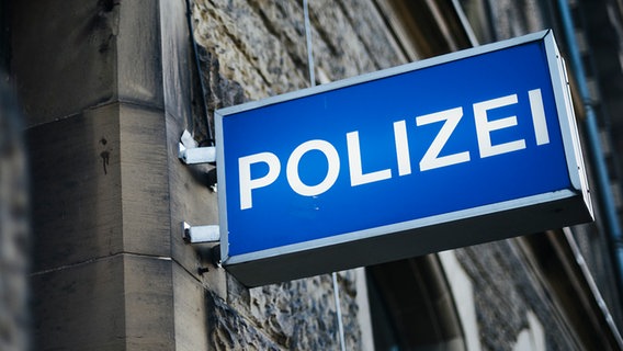 An einer Hausfassade hängt ein Leuchtschild mit der Aufschrift Polizei. © NDR Foto: Julius Matuschik