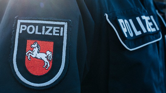 Auf dem Jackenärmel einer blauen Polizeiuniform ist das niedersächsische Wappen aufgenäht. © NDR Foto: Julius Matuschik
