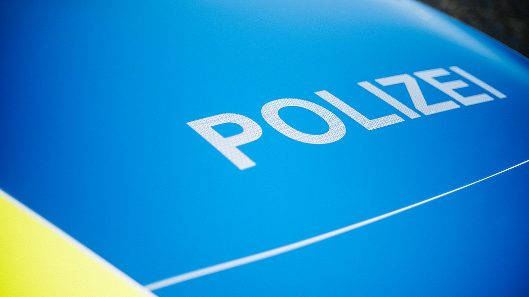 Auf einer blauen Motorhaube steht der Schriftzug Polizei.