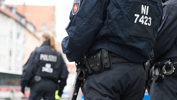 Polizeibeamte stehen vor einem Gebäude. © Picture Alliance Foto: Swen Pförtner