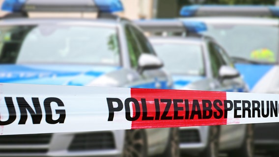 Eine Polizeiabsperrung mit mehreren Polizeiautos im Hintergrund. © picture alliance/CHROMORANGE Foto: Udo Herrmann