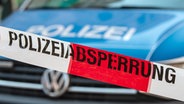 Ein Flatterband mit der Aufschrift "Polizeiabsperrung" ist vor einem Fahrzeug der Polizei zu sehen. © picture alliance/dpa Foto: Swen Pförtner